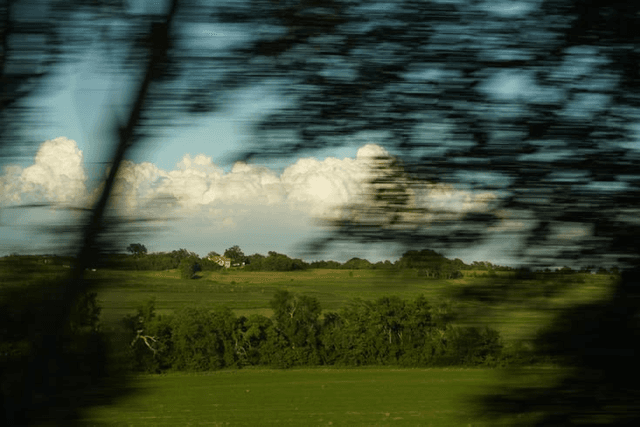 A landscape moving past a train window